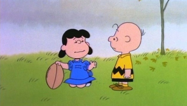 Lucy and Charlie Brown play football